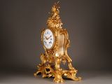 a gold clock sitting on top of a table