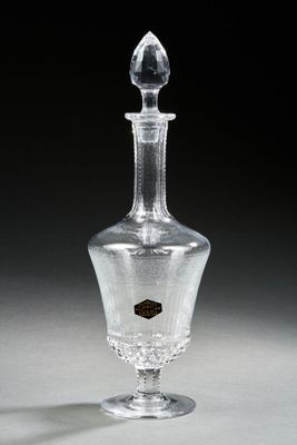 une bouteille en verre transparent avec une étiquette noire dessus