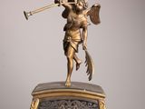 a statue of an angel playing a trumpet on top of a clock