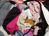 une pile de vêtements posée sur un lit