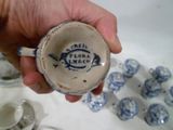 une personne tenant une tasse à la main, avec de nombreuses tasses en arrière-plan