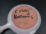 a pink bowl with writing on it sitting on a table