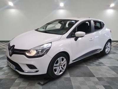 la voiture blanche est garée sur un sol en damier dans le garage