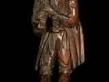 bronze statue of a man with a hat and a coat