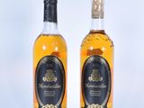 deux bouteilles de whisky posées l'une à côté de l'autre sur une surface blanche