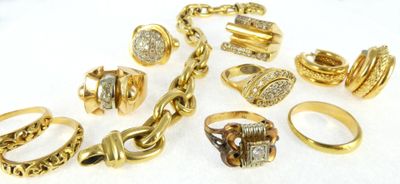 several different types of gold rings and bracelets on a white surface