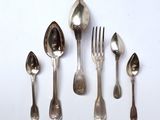several spoons, forks and spoons are lined up on a white surface