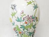 a white vase with a red and green design on it