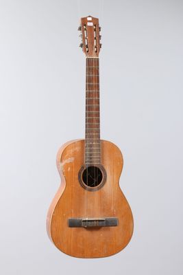 an image of a small wooden guitar hanging from the ceiling