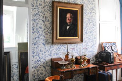 un tableau accroché au mur d'une pièce où se trouvent une table et des chaises