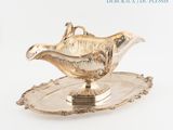 a silver plate with a silver saucer on top of it