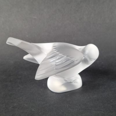 a glass bird that is sitting on a table