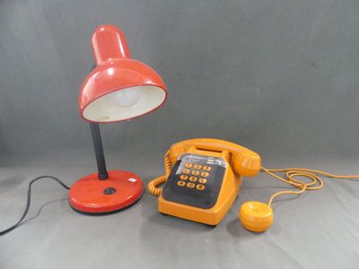 un téléphone jaune et une lampe rouge posés sur une table