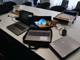 Plusieurs ordinateurs portables sont posés sur une table dans une salle de réunion