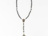 a rosary necklace with a cross on it and black beads
