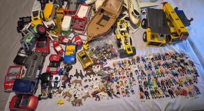 a lot of toys on a bed with a white sheet