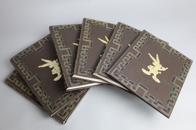 five brown books with gold designs are stacked on top of each other