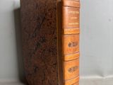 un vieux livre à la couverture brune posé sur une table