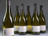 six bottles of wine are lined up in a row on a table