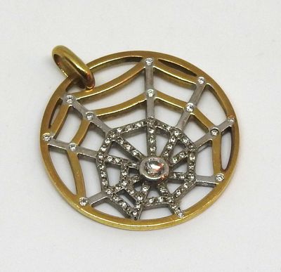une image représentant un pendentif en or et en argent orné d'une toile d'araignée