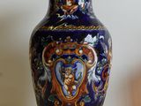 un vase bleu posé sur une table à côté d'une bougie
