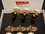 a white box with four gold tone guitar heads in it