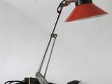 an image of a red and black desk lamp on a white background