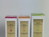 three boxes of perfume sitting next to each other on a white surface