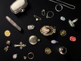 an assortment of silver and gold jewelry on a black background