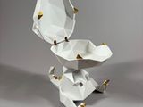 a white origami with gold spikes on top of it