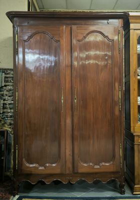 a large wooden cabinet in a room with a rug on the floor