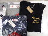 a lot of t - shirts that are sitting on a table
