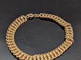 gros plan d'un bracelet en chaîne en or sur une table
