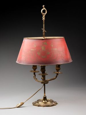 une lampe de table en laiton ancien avec un abat-jour rose sur fond noir