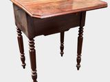 an old wooden table with turned legs and a wooden top
