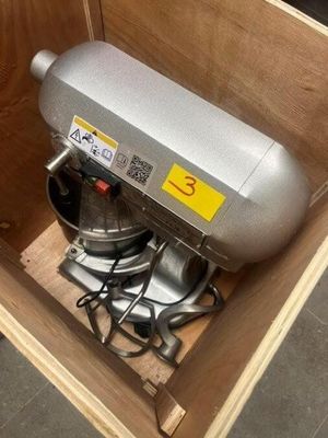 a metal mixer sitting inside of a wooden box