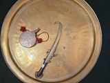 une assiette en or sur laquelle sont représentés un couteau et un cœur