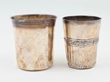 deux tasses en argent posées l'une à côté de l'autre sur une surface blanche