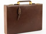 porte-documents en cuir marron sur fond blanc, avec des poignées découpées