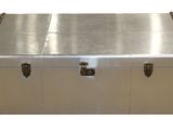 an image of a silver trunk with orange handles and a metal lid