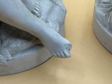two statues of a woman and a child on a table
