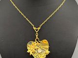 a gold necklace with a heart shaped pendant on a mannequin