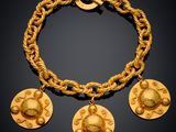 an image of a gold bracelet with four charms