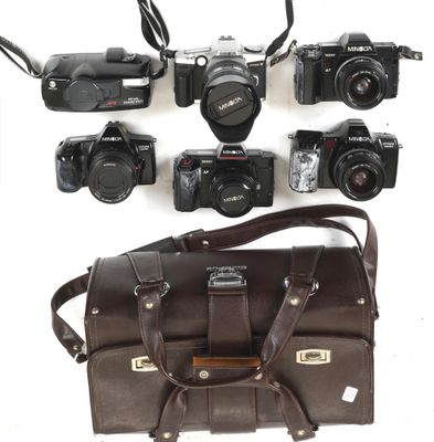 de nombreux types d'appareils photo et un sac posés sur la table