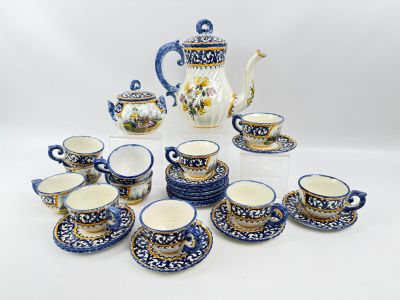 plusieurs tasses et soucoupes et une théière sur la table