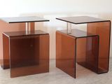 une paire de tables d'appoint en verre marron posées sur un sol blanc