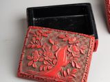 pair of small red and black boxes with birds on them