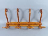 a wooden coat rack with four hooks on it