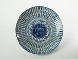 une assiette bleue et blanche ornée d'un motif