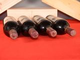 several bottles of wine sit in a wooden box on a red table